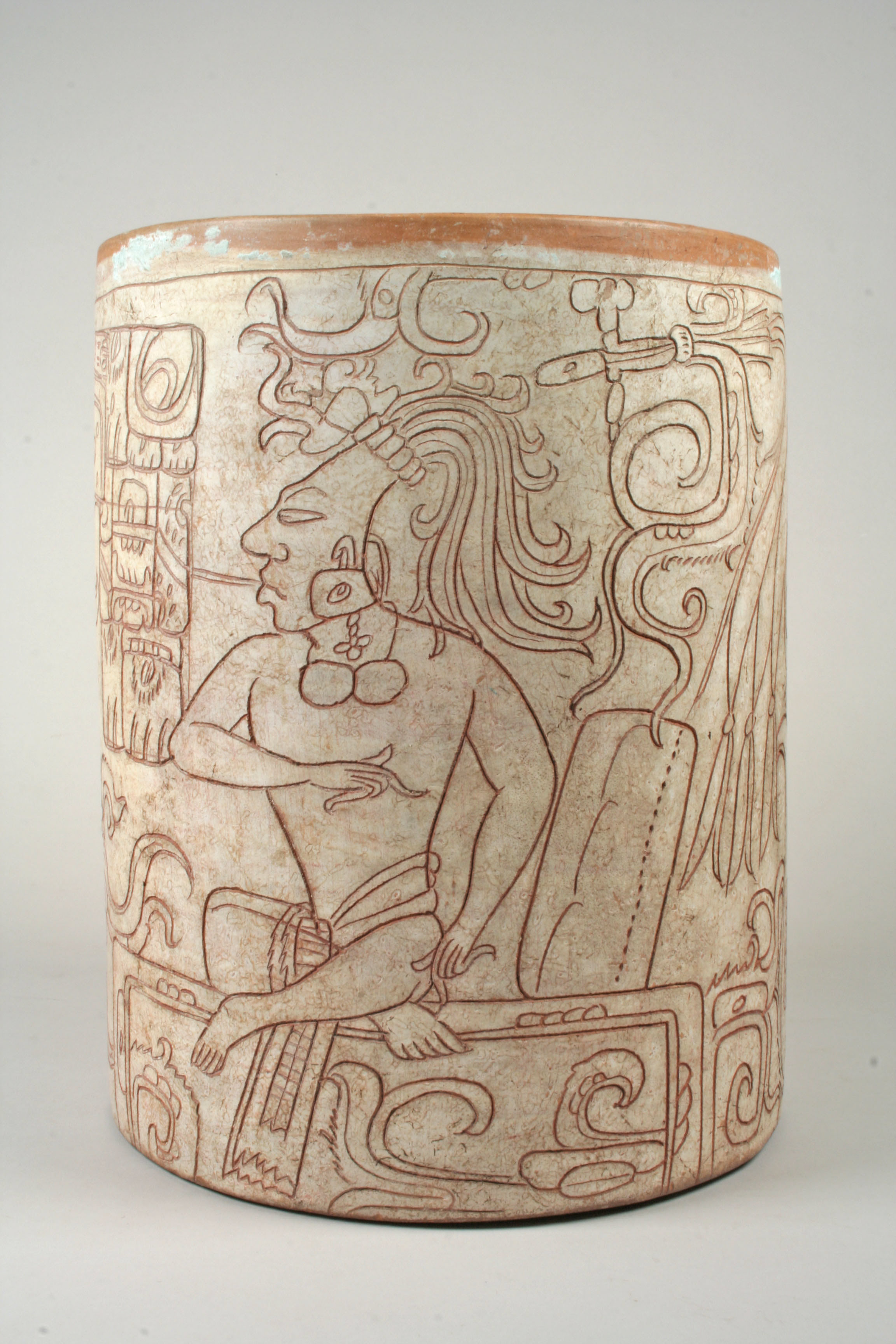 A ceramic cup with a scene of a seated lord carved into the side. 